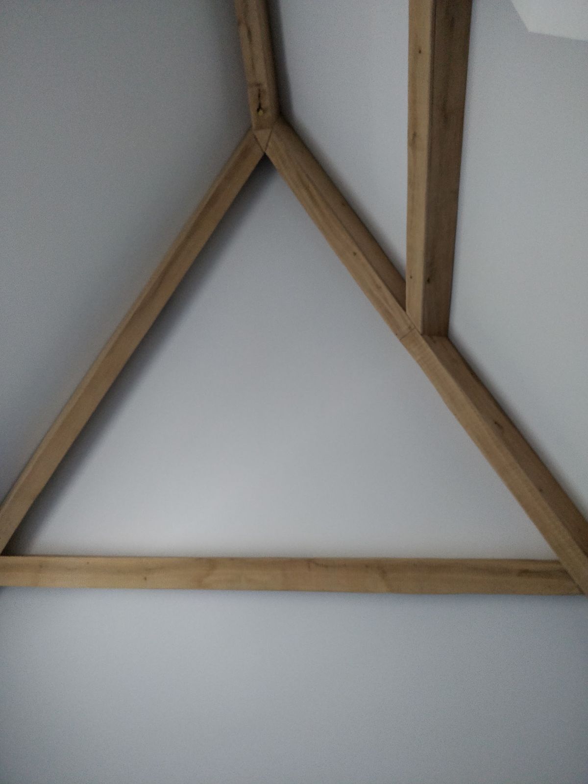 Houten spant tegen een wit schuin plafond